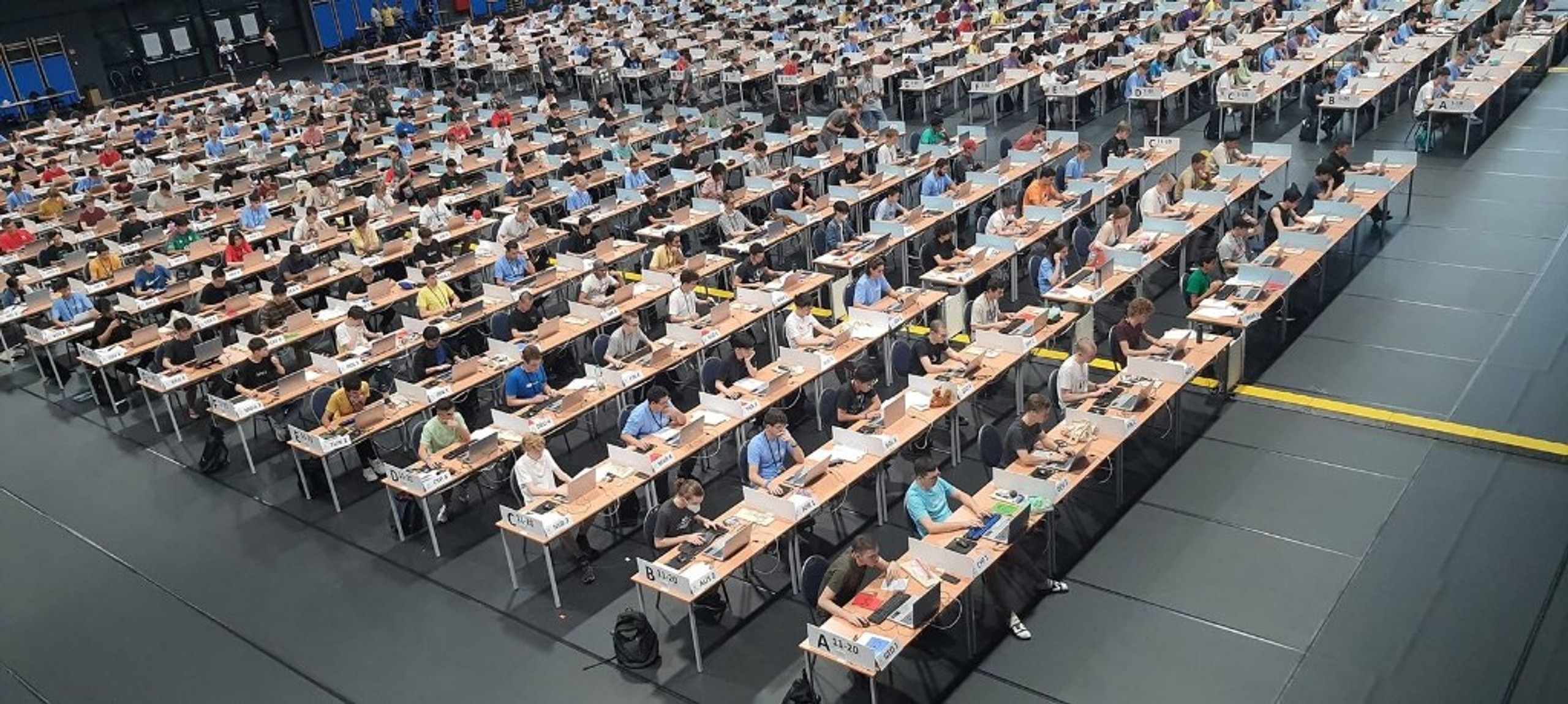 International programming competition hall with country-labeled workstations
